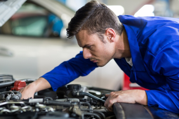Mechanic removing a used oil filter during an engine service